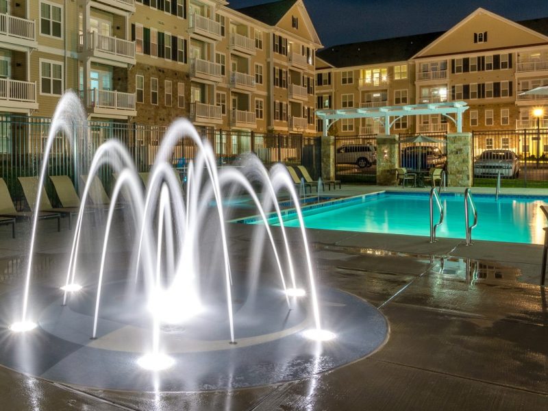 This image shows an eye-catching splash pad with a swimming pool overview at night.
